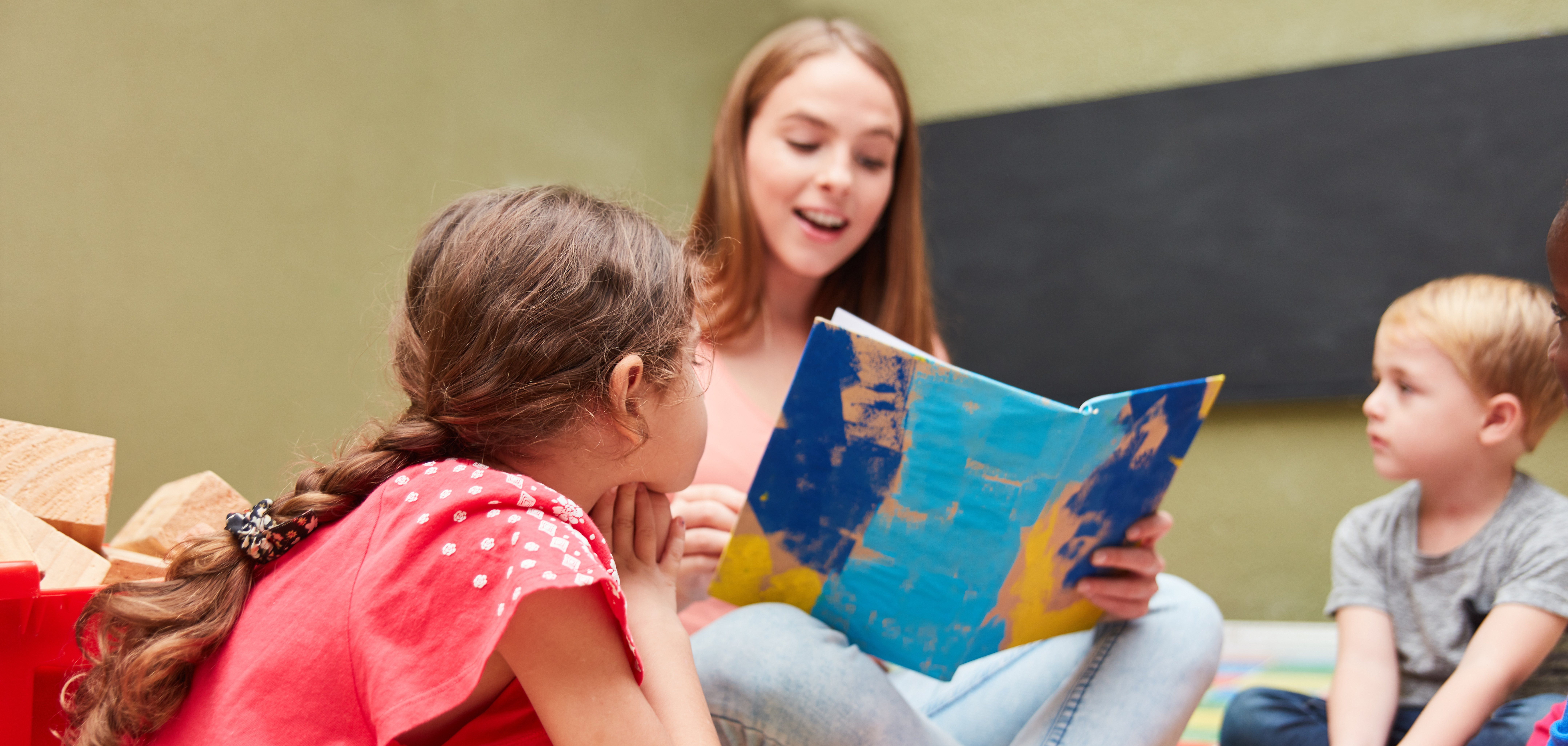 Tagesmutter und Kinder beim Vorlesen 