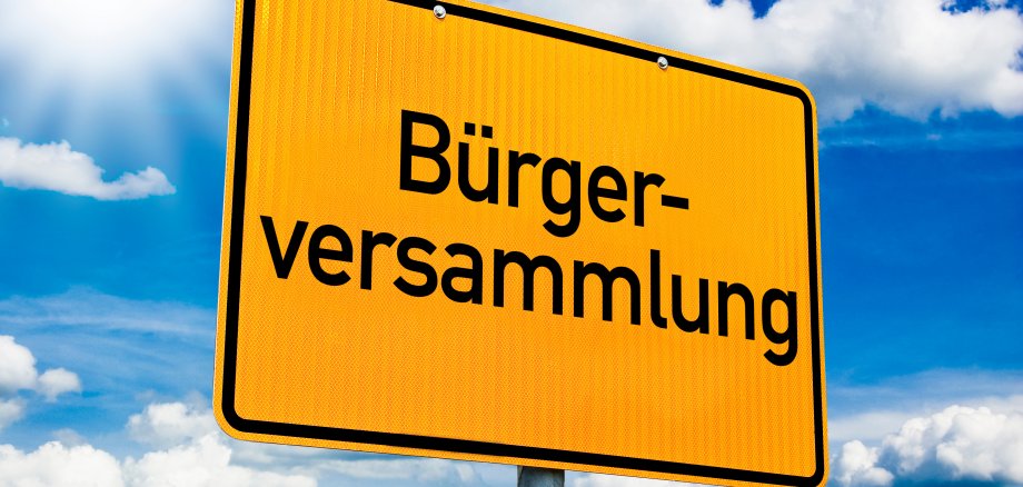 Schild mit Bürgerversammlung Gelbes Ortsschild, auf welchem das Wort Bürgerversammlung steht