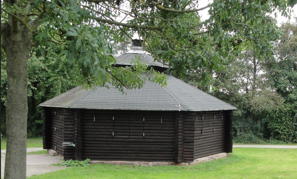 Grillhütte aus Holz  in Rundbauweise auf einer Wiese