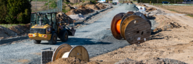 Baustelle zur Erschließung des Baugebiets Ringstraße mit Kabelrollen, Baumaschinen und anderem Gerät.