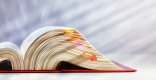 Gesetzbuch Aufgeklapptes rotes Gesetzbuch mit Klebezetteln vor einem unscharfem grauen Hintergrund.