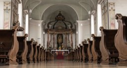 Bild des Innenraums der Pfarrkirche Sankt Maria Magdalena in Gernsheim aus Froschperspektive. Links und rechts die Bankreihen. Blick auf den Altar.