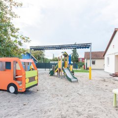 Ein Teilbereich des Außengeländes ist zu sehen mit verschiedenen Spielgeräten.