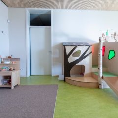 Der U3 Gruppenraum zeigt eine kleine Spielküche und eine Hochebene.