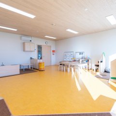 Der Ü3 Gruppenraum ist in die verschiedenen Bereiche eingeteilt. Es ist eine Rollenspielecke und eine TIschgruppe zu sehen.