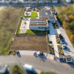 Das Bild zeigt das komplette Gebäude mit Außengelände aus der Vogelperspektive.