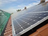 Man sieht eine Seite eines Spitzdachs des Gebäudes Auerbacherstraße auf dem Solarpanelen sind