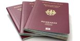 Drei deutsche Reisepässe liegen aufgefächert  auf hellem Untergrund.