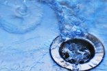 Wasser, das in ein Abflußsieb läuft