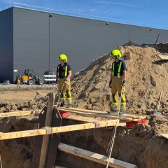 Feuerwehrleute in Schutzkleidung arbeiten gemeinsam an einer Übung im Bereich Technische Hilfeleistung am Bau.