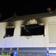 Wohnhaus. Die Fenster und das Dach sind nach einem Brand rußgeschwärzt.