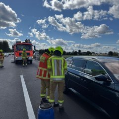 An einem verunfallten PKW wird die Batterie abgeklemmt.
