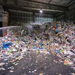 Ein in Brand geratener Müllhaufen wird von Feuerwehrkräften abgelöscht.