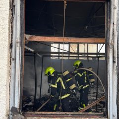 Ein Trupp unter Atemschutz löscht letzte Glutnester in einer Lagerhalle ab.