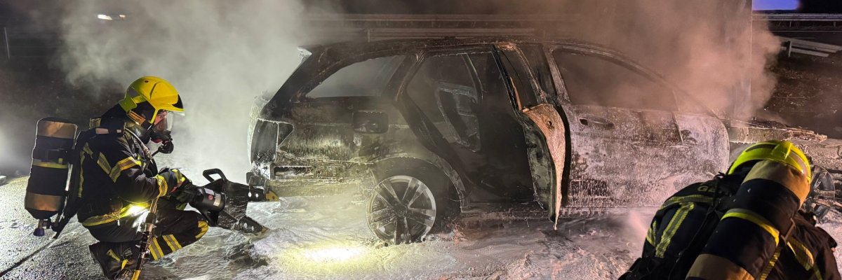 Der Angriffstrupp hebt das Fahrzeug an, um die Glutnester am Unterboden ablöschen zu können