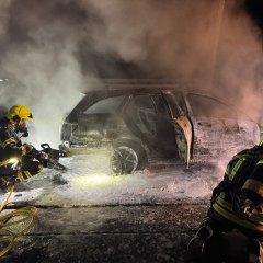 Der Angriffstrupp hebt das Fahrzeug an, um die Glutnester am Unterboden ablöschen zu können