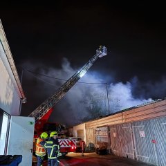 Die Drehleiter der Feuerwehr unterstützt die Löscharbeiten von oben aus.