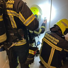 Feuerwehrkräfte versucht mittels Türöffnungswerkzeug eine Wohnungstüre gewaltfrei zu öffnen.