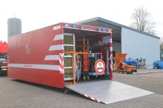 Ein geöffneter Abrollbehälter Dekontamination Geräte (AB-Dekon-G). Im Hintergrund eine Fahrzeughalle.