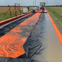 Eine aufgebaute Fahrzeugdekontaminationsschleuse. Im Hintergrund ein Acker.