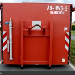 Roter Abrollbehälter der Feuerwehr für Hochwasserschutz (AB-HWS-2).