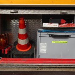Rotes Feuerwehrfahrzeug, ein Gerätewagen Logistik (GW-L 2), geöffneter Gerätekästen der linken Fahrzeugseite mit Beladung.