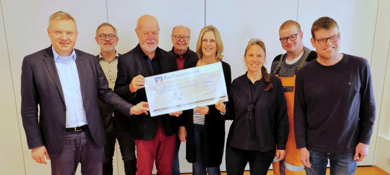 Übergabe eines großen Schecks, Zu sehen von links: Bürgermeister Peter Burger, Sascha Marx, Norbert Müller, beide von der Bürgestiftung, Behindertenbeauftragter Hans-Josef-Becker, Sabine Bierhals, Nicole Fries-Pulz, Robin Pulz und Sascha Bierhals.