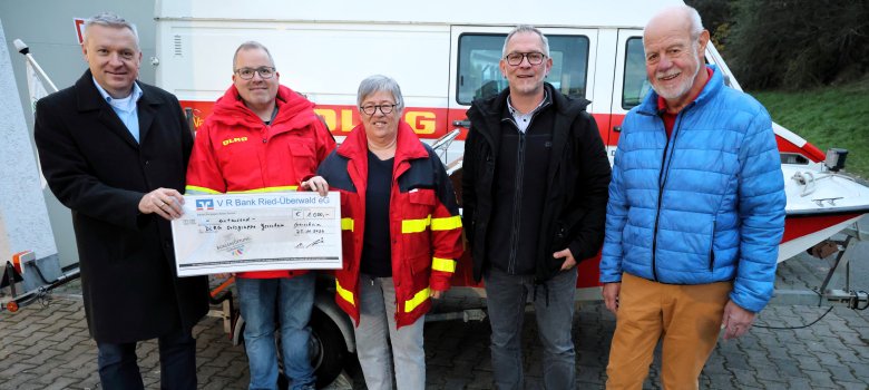 Übergabe eines großen Schecks, zu sehen sind von links: Bürgermeister Peter Burger, Tobias Pöschl, Ingrid Maul (beide DLRG), Sascha Marx und Norbert Müller (beide Bürgerstiftung).