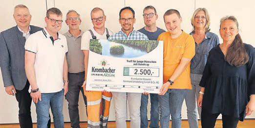 Übergabe eines großen Schecks, zu sehen sind v.l.n.r.: Vorstandsvorsitzender der Bürgerstiftung Peter Burger, Sascha Bierhals, Sascha Marx (Bürgerstiftung), Robin Puls, Sven Oelmann (Gebietsleiter Krombacher Brauerei), Julian Bierhals, Julian Fries, Sabine Bierhals und Nicole Puls-Fries.